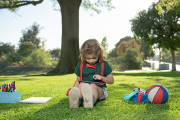 Aufkleber - Nerd pupil. Little child learning outdoor by studying online and working on tablet in green field.