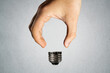 © Northern life - Man holding invisible bulb and visible socket on light background. Negative space