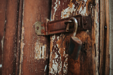 Sticker - Closeup shot of a rusty padlock hanging on an old wooden door