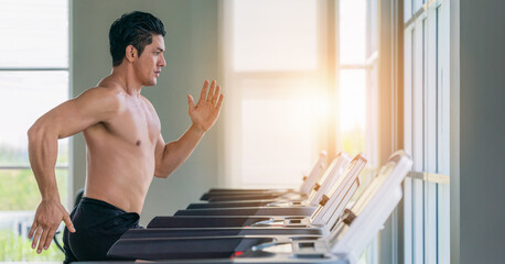 Wall Mural - athletic man doing running exercise on treadmill in gym and fitness center