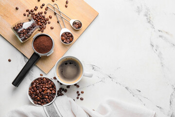 Composition with cup of coffee, beans and powder on light background