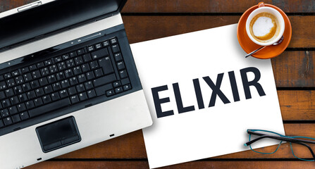 Elixir Programming Language.  Word Elixir on paper and laptop 