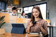 © Nopphon - Young beautiful business woman working with tablet sitting in coffee shop cafe.