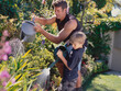 © SuperStock - Father and Son watering garden with watering cans