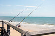 © SuperStock - Fishing rods attached to the railing of a balcony on the beach