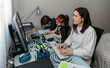 © David Pereiras - Woman teleworking with her children doing homework. Selective focus on woman in foreground