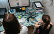 © David Pereiras - Top view of unrecognizable woman teleworking with her daughter drawing side by side