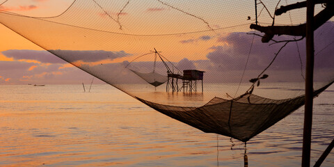 Wall Mural - silhouette of fisherman net during sunset in phattalung thailand