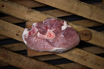 Pork meat on a wooden background. Raw pork leg. Fresh raw meat.