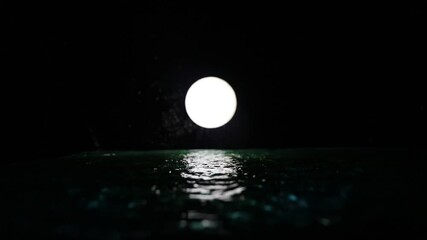 Wall Mural - Romantic and scenic panorama with full moon on sea to night. Table decoration with moon miniature and water. Slider shot
