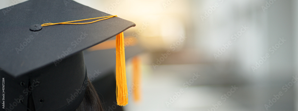 Young happy Asian woman university graduate in graduation gown and cap in the college campus. Education stock photo - obrazy, fototapety, plakaty 