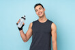 © luismolinero - Young sport man over isolated on blue background with sports water bottle
