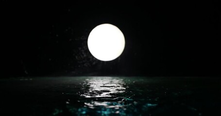 Wall Mural - Romantic and scenic panorama with full moon on sea to night. Table decoration with moon miniature and water. Slider shot