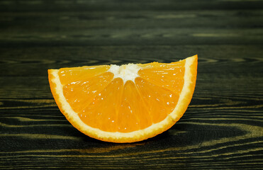 Wall Mural - slice of fresh juicy orange on a coarse dark wooden background