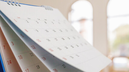 Close up white paper desk calendar with blurred bokeh background appointment and business meeting concept