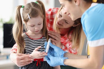 Little girl has doctor taking blood test with lancet