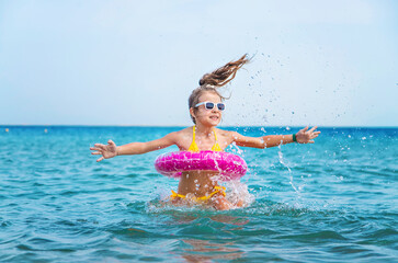 Poster - The child splashes water in the sea. Selective focus.