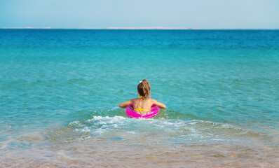 Poster - The child swims in a circle in the sea. Selective focus.