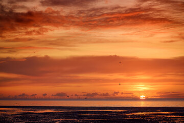 Beautiful sunset colors over the coastline of Allerdale district in Cumbria, UK. Sun setting over the shore of Allonby bay on autumn.