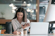 © NAMPIX - Young beautiful asian woman working on tablet and laptop computer while sitting at her desk office.
