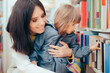 © nicoletaionescu - Happy Mother and Daughter Looking at a Book in a Library