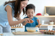 © chomplearn_2001 - Happy mother and little child boy have good time together in kitchen, learning about food, boy Mother's day