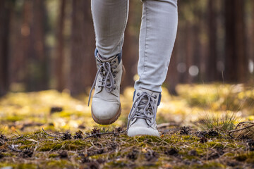 Wall Mural - hiking boots. hiker walking in woodland. female legs wearing leather sports shoes in forest