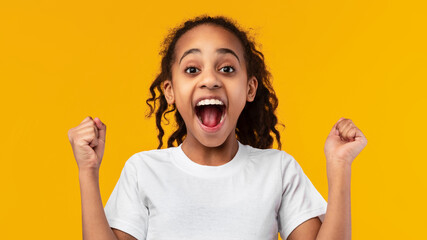 Wall Mural - Portrait of emotional black girl screaming with raised fists