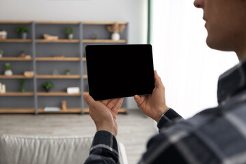 Poster - Guy Holding Tablet With Blank Screen Over Living Room Background