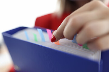 Woman's hand takes out sticker from folder with documents