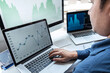 © Thitiphat - Businessman investor working in traders marketing and planning and analyzing pointing on the stock chart data presented and deal on a stock exchange to business profit