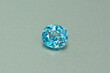 Genuine, natural mined, bright neon blue lagoon color, cushion shaped, heated loose zircon flawless gemstone setting for jewelry making. Light gray gradient background.