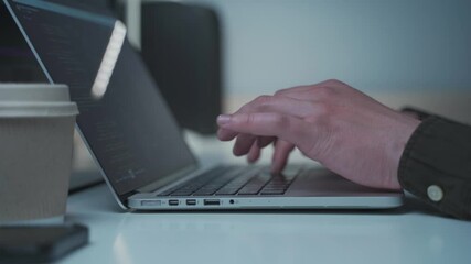 Programmer in headphones cancel noise working on new software development behind computer and laptop. Application developer working on computer in office. Work from home, remote working concept