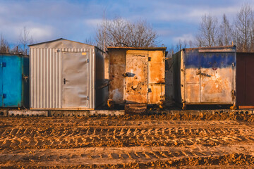 Old iron trailers on the construction site with footprints and patterns from wheels and tires of industrial transport on the sand