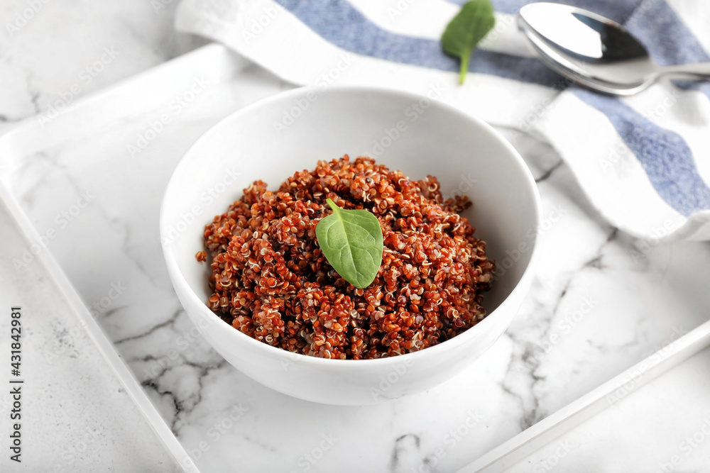 Bowl with tasty quinoa on light background