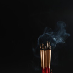 Burning incense white smoke black background used as a worship background image a sacred object of Buddhist beliefs focuses on the smoke.