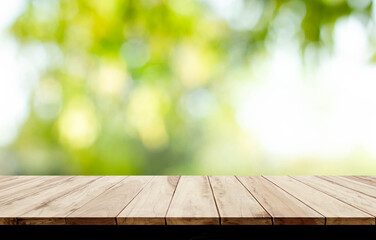 blurred background of green park in summer, Wood table top on shiny bokeh green background. For product display