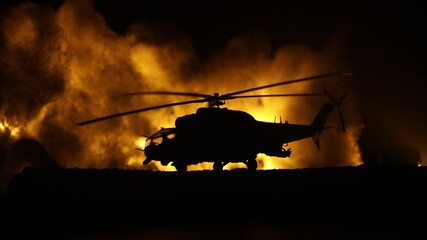 Wall Mural - Silhouette of military helicopter ready to fly from conflict zone. Decorated night footage with helicopter starting in desert with foggy toned backlit. Selective focus. War concept