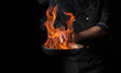 © Віталій Б. - Chef cooking food in pan with fire flame on black background. Restaurant and hotel service concept. Free advertising space