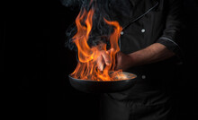 Chef Cooking Food In Pan With Fire Flame On Black Background. Restaurant And Hotel Service Concept. Free Advertising Space