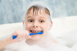 © Konstiantyn Zap - The boy in the foam is brushing his teeth in the bathroom. Dental care, hygiene.