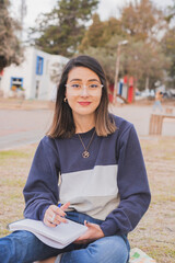 Wall Mural - Female Hispanic student studying in the park