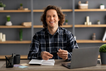 Poster - Happy Young Businessman Posing Sitting At Laptop In Office