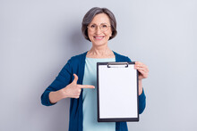 Photo Portrait Of Senior Business Woman Pointing Finger At Blank Space Keeping Clipboard Isolated On Grey Color Background