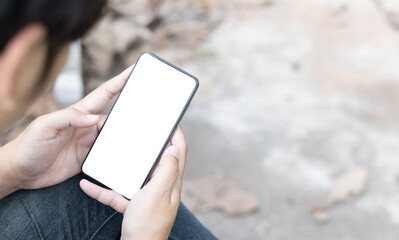 Hand holding and using smartphone with white blank on screen.