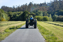 Scene Of An Old Tractor Seen From Behind On A Road In A Rural Area. Galicia, Spain