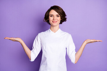 Sticker - Photo of bob brunette haired young woman professional cook hold hands empty space scales isolated on violet color background