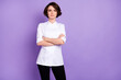 Photo of serious confident young woman profession cook hold hands crossed isolated on purple color background