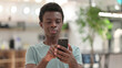 © stockbakers - Young African Man Using Smartphone, Text Messaging