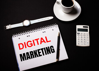 Fototapete - Coffee in a white cup, a wrist watch and a calculator on a black table. Nearby is a pen and a notebook with the text DIGITAL MARKETING